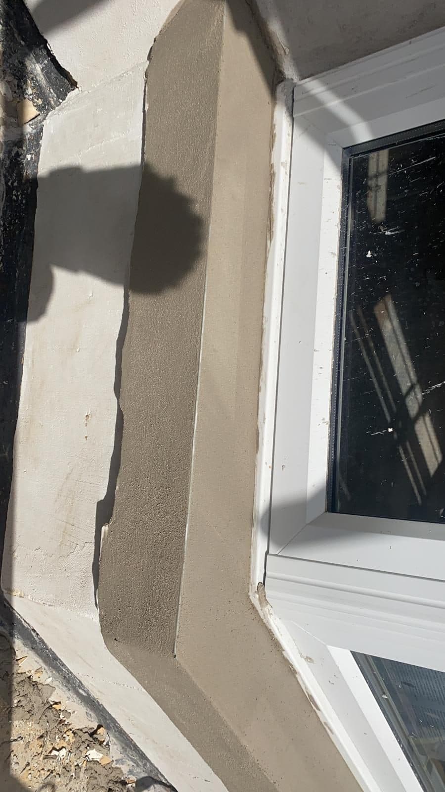 Close-up of freshly rendered brickwork and a window reveal on a UK property